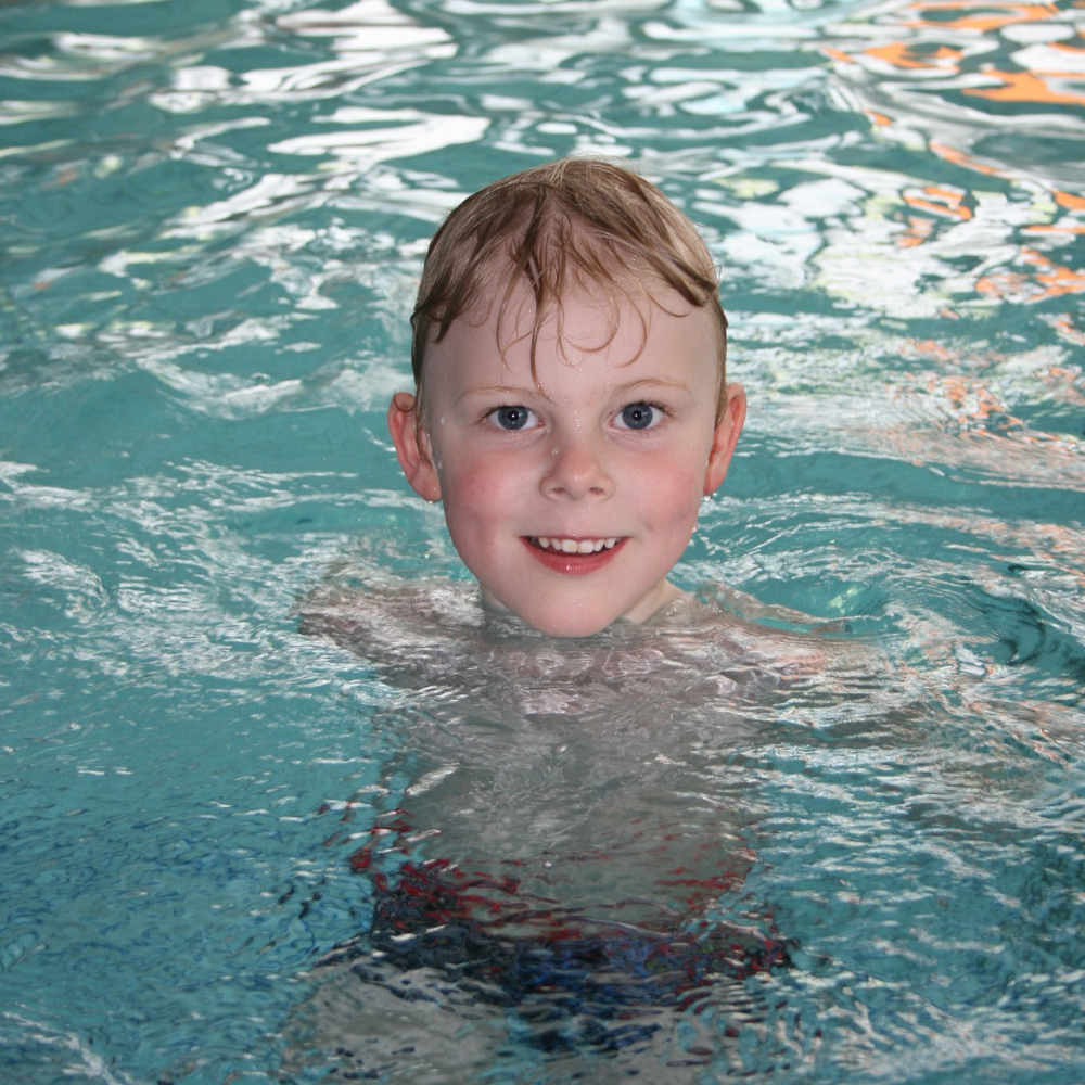 Junge beim schwimmen im Hallenbad 